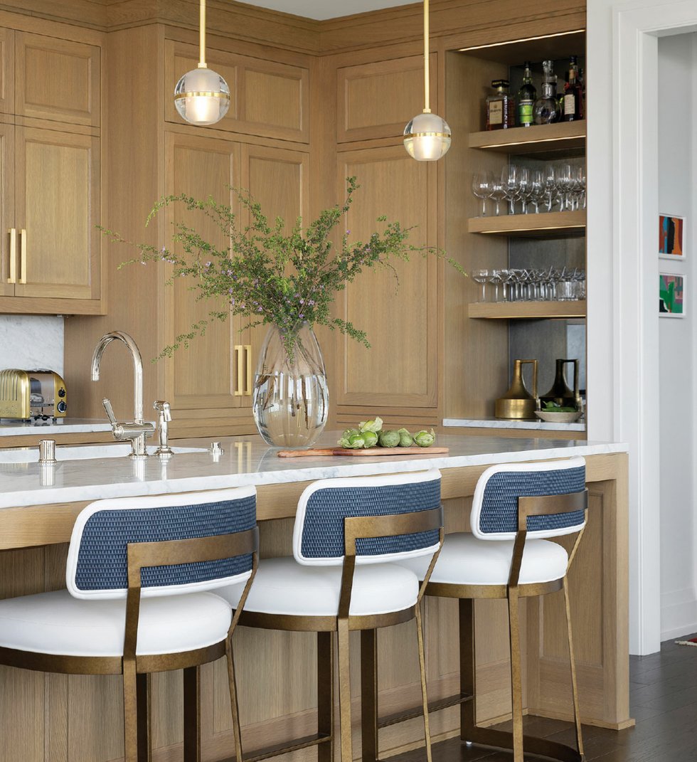 The kitchen’s white oak cabinets, brass hardware, and Carrara marble countertops came together as expected.