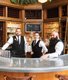 three bartenders behind the bar